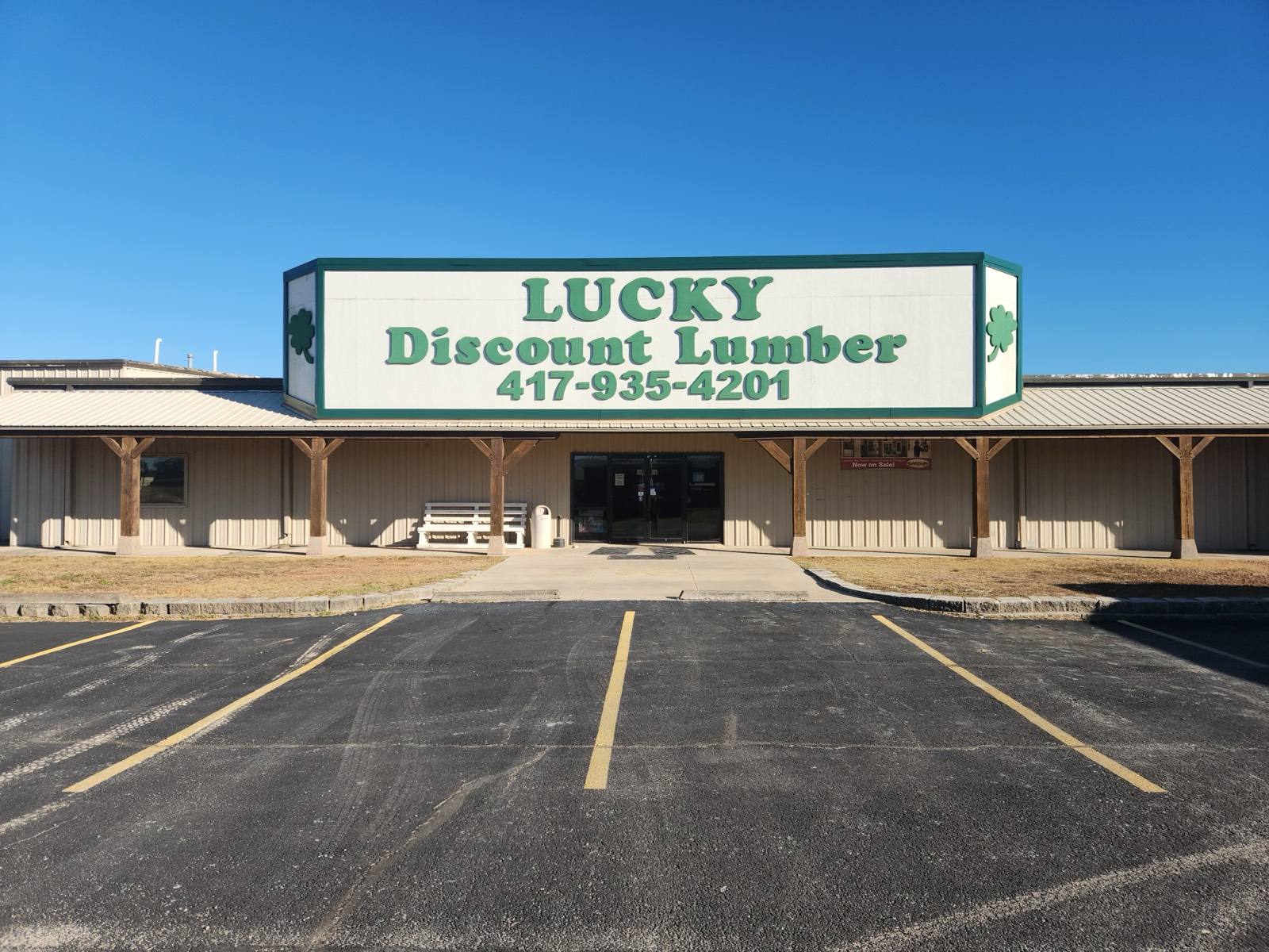 The Lucky Discount Lumber storefront in Seymour, with the green and white sign and phone number